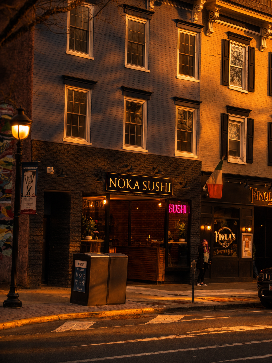 Nōka Sushi and Finola's storefronts on Main Street at golden hour